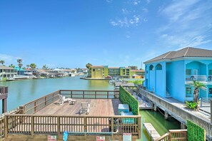 A waterfront property with a wooden deck, a no diving sign, and a view of the water and buildings. - Updated Fiesta Isles Condo w/ Bay Views & Pool! (South Padre Island)
