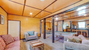 A cozy room with wooden walls, a pool table, and two sofas. - Lakefront Gem: Hot Tub & Game Room in Hancock (Hancock)