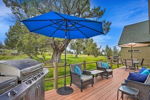 A deck with a barbecue grill, outdoor furniture, and a blue umbrella. - Eagle Crest Retreat w/ Great Wifi & Resort Access! (Redmond)