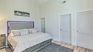 A bedroom with a bed, a ceiling fan, a nightstand, and a door. - Contemporary Cincinnati Condo - Pets Allowed! (Cincinnati)