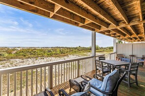 A wooden deck with outdoor furniture, a railing, and a view of the beach. - Oceanfront St Helena Island Condo w/ Beach Access! (Harbor Island)