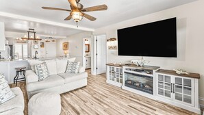 A modern living room with a sofa, a television, and a fireplace. - Oceanfront St Helena Island Condo w/ Beach Access! (Harbor Island)