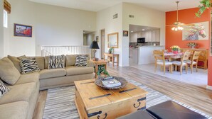 A spacious living room with a sofa, coffee table, and dining area. - 112117: Spacious 3 BR La Quinta Condo on PGA West! (La Quinta)