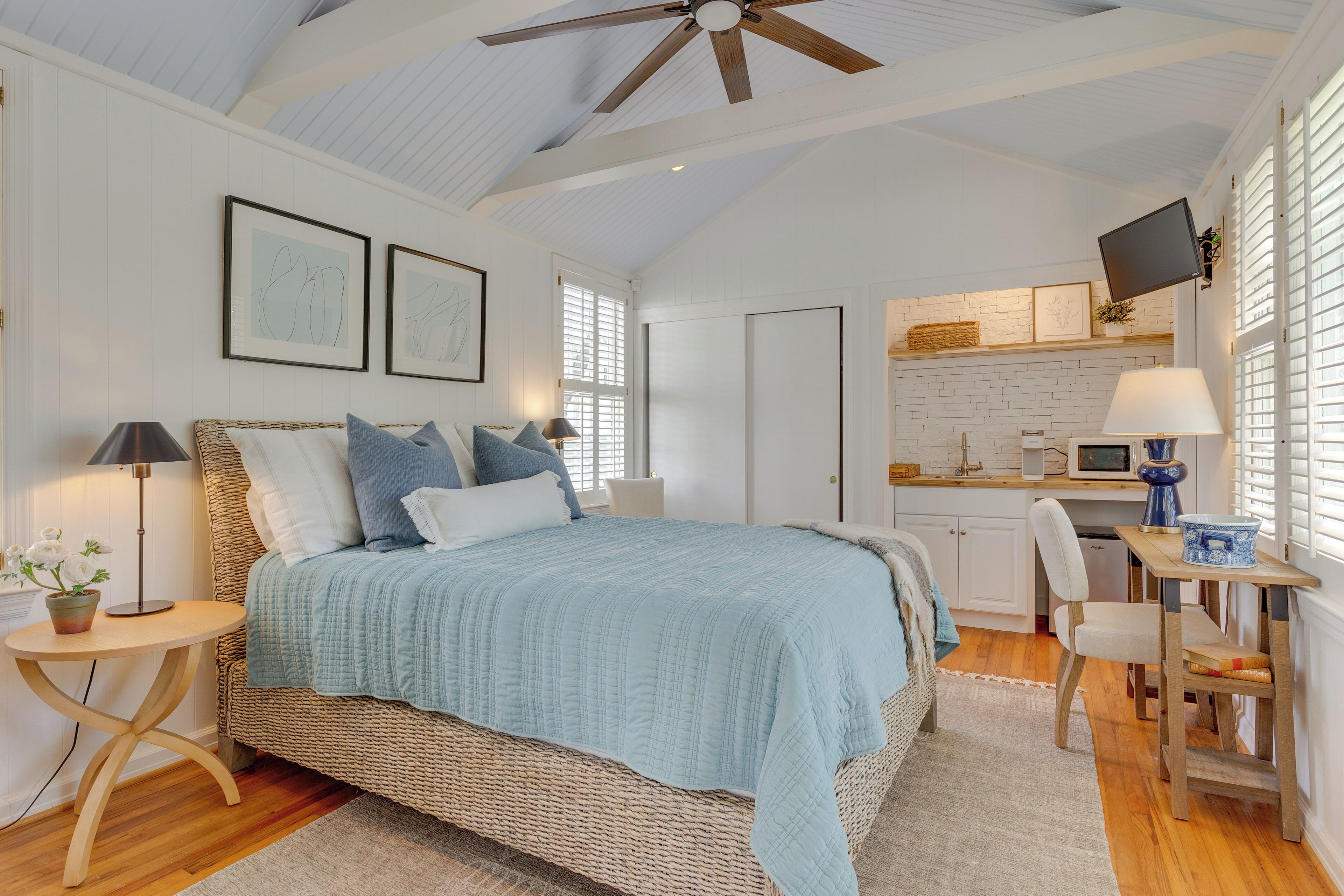 A spacious bedroom with a large bed, a dining area, and a kitchen.