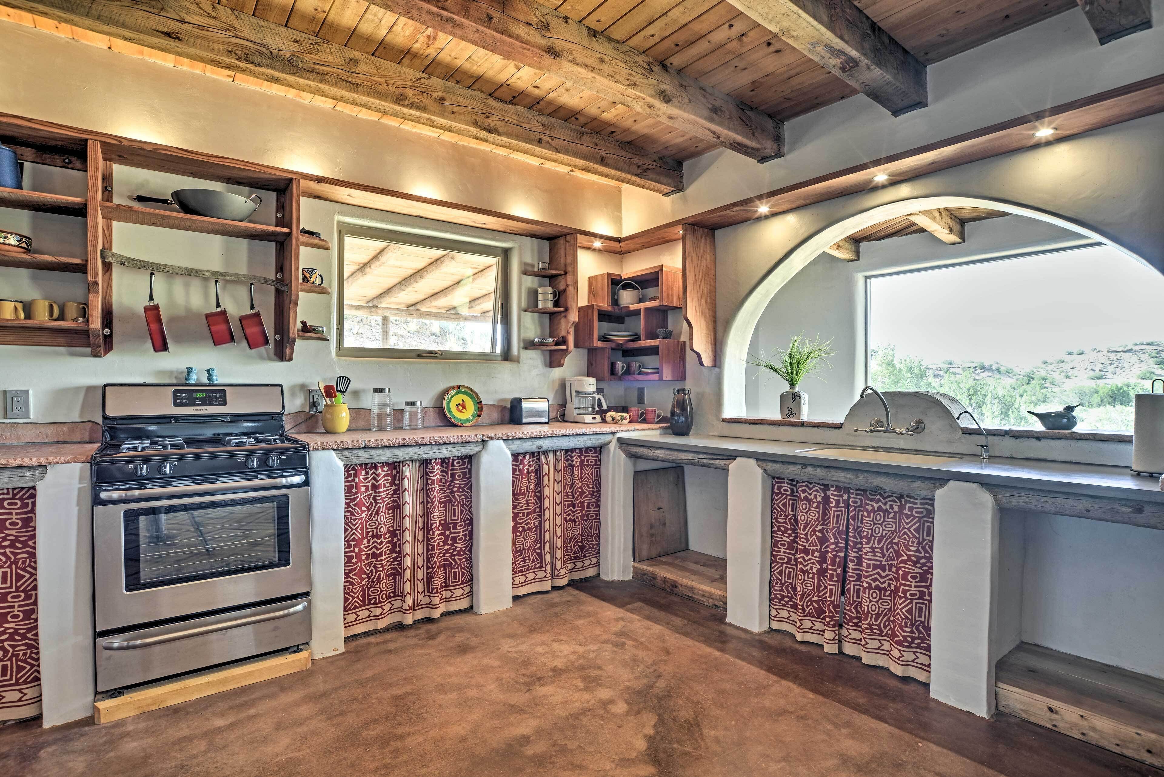 A kitchen with a built-in oven, a stove, and wooden shelves.