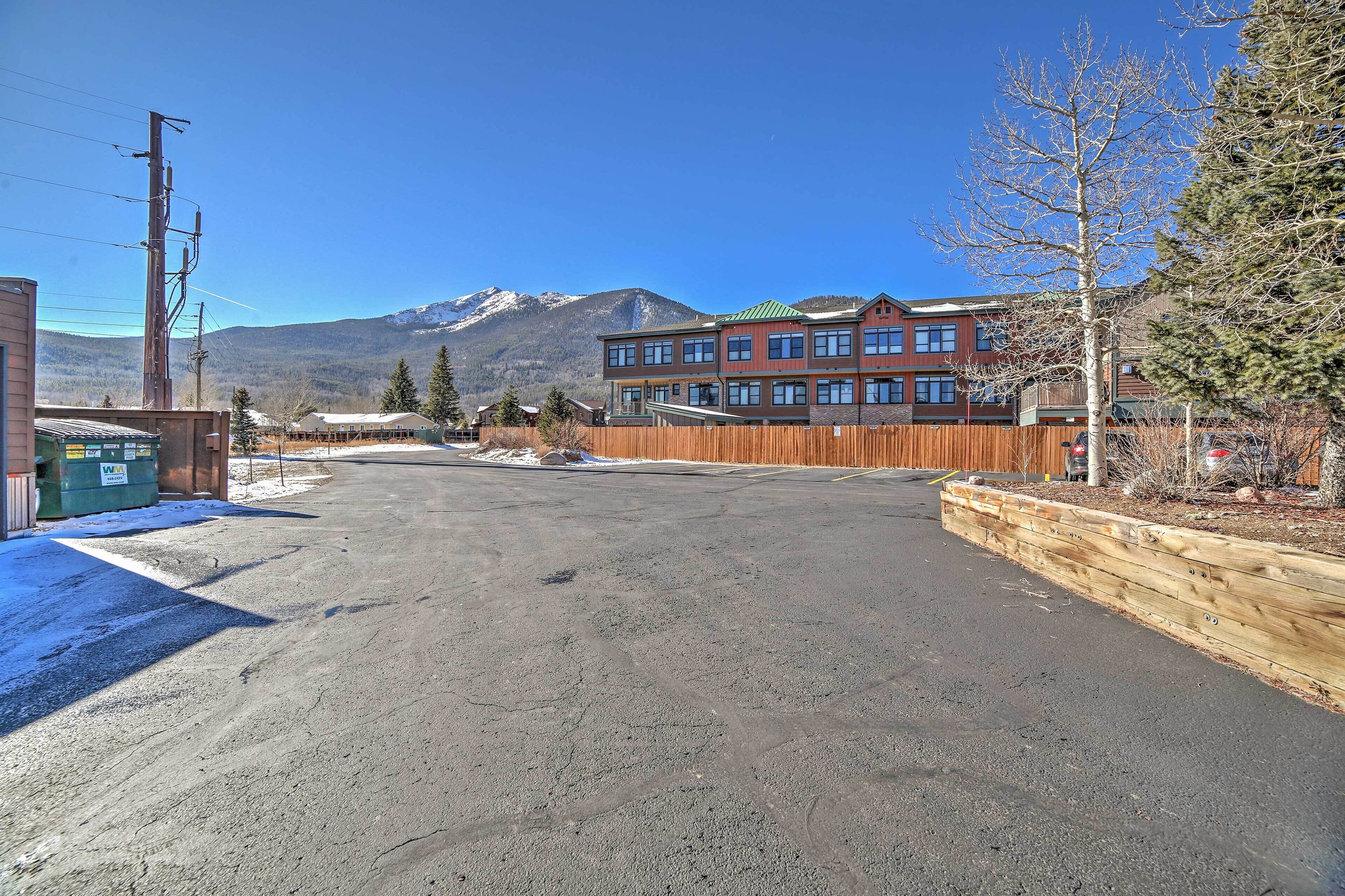 A building with multiple windows and a flat roof, surrounded by a wooden fence and a snow-covered ground.