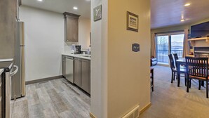 A modern kitchen with stainless steel appliances, a dining area with a wooden table and chairs, and a view of the outdoors through large windows. - Walk to Main Street: Frisco Townhome w/ Decks (Frisco)