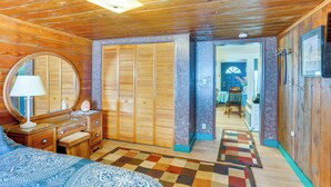 A wooden interior with a bed, dresser, mirror, and a hallway leading to another room. - Dunsmuir Apartment ~ 17 Mi to Mt Shasta Ski Park! (Dunsmuir)