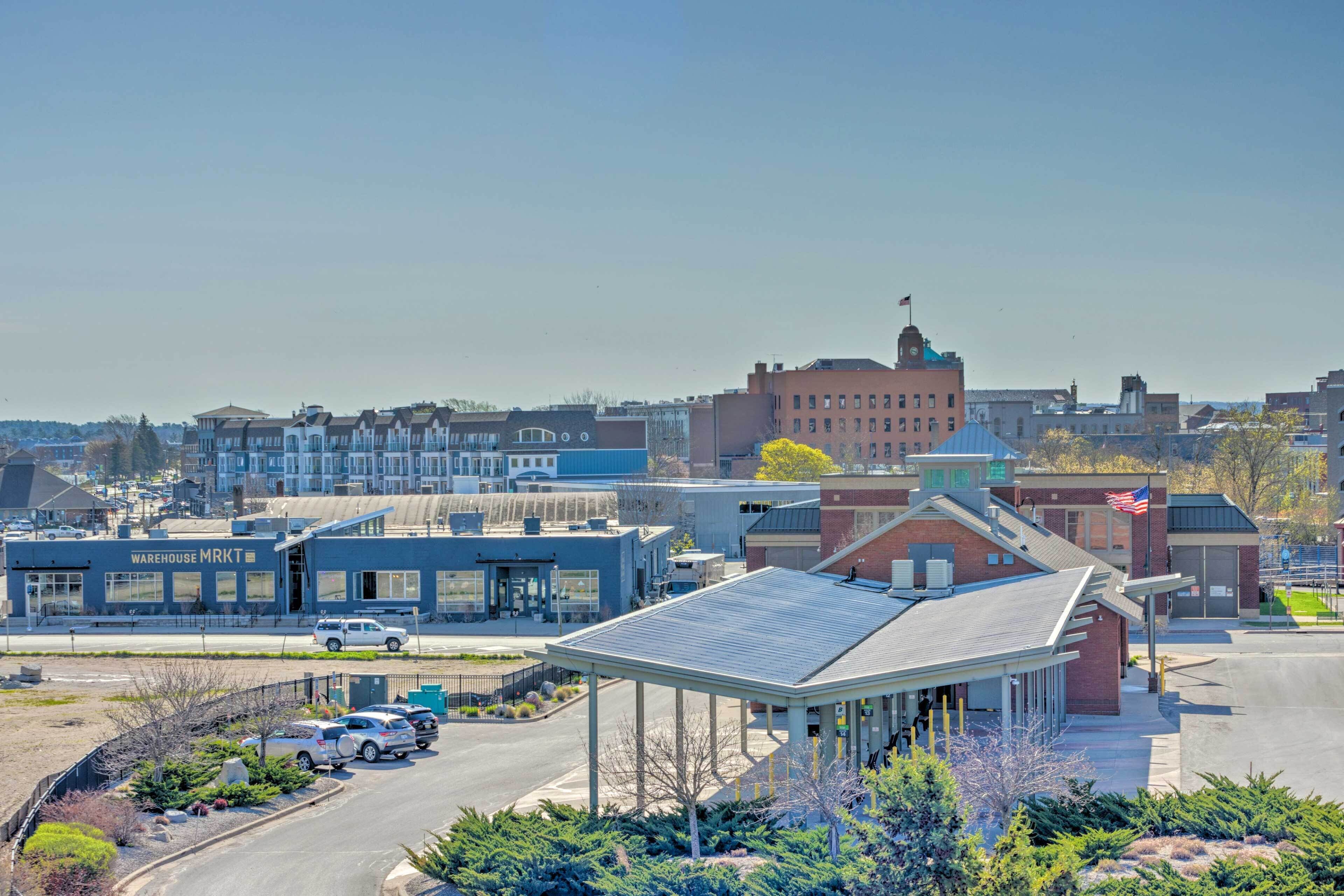 A warehouse building with a blue facade and a parking lot with several cars.