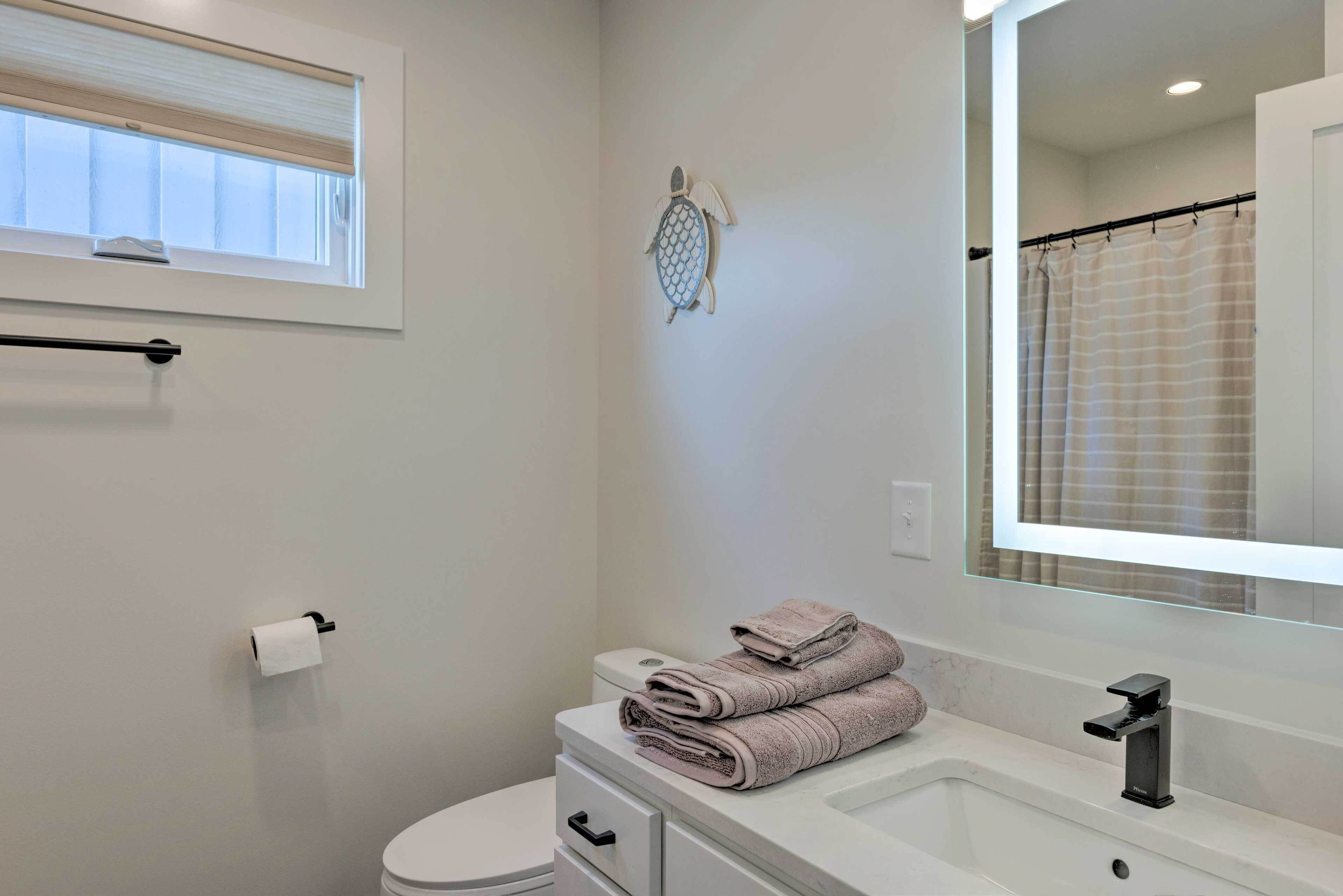 A bathroom with a toilet, sink, and a towel rack.