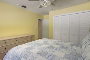 A bedroom with a bed, dresser, closet, and ceiling fan. - Riviera Beach Home w/ Pool - Walk to Beaches! (Singer Island)