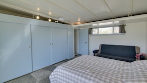 A bedroom with a bed, a sofa, a wardrobe, and a window. - Patio & Views: Eccentric Desert Hot Springs Home (Desert Hot Springs)