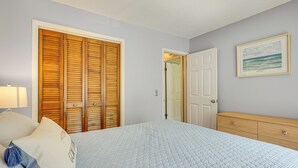 A bedroom with a bed, a wooden wardrobe, a dresser, and a framed picture on the wall. - Mount Pleasant Condo - Near Charleston & Beaches! (Mount Pleasant)