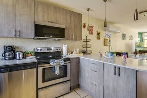Una cucina moderna con elettrodomestici in acciaio inossidabile, mobili in legno e un piano di lavoro in marmo.