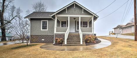 A two-story house with a front porch, a driveway, and a lawn.