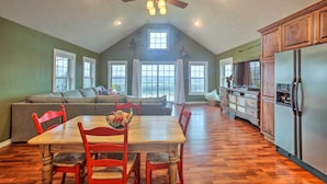 A spacious kitchen with a dining area, wooden cabinets, and a ceiling fan. - Riverfront Arkansas Retreat Near Fishing & Hiking! (Cotter)