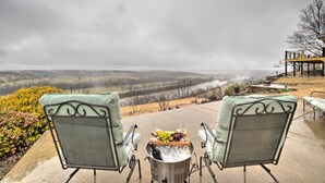 Two outdoor patio chairs facing a scenic view of hills and a body of water. - Riverfront Arkansas Retreat Near Fishing & Hiking! (Cotter)
