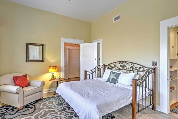 A bedroom with a bed, a chair, a lamp, and a wardrobe. - Carpinteria Apt w/ Hot Tub - 10 Min Walk to Beach! (Carpinteria)