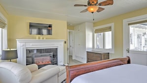 A bedroom with a bed, a fireplace, a ceiling fan, and a TV mounted on the wall. - Carpinteria Apt w/ Hot Tub - 10 Min Walk to Beach! (Carpinteria)