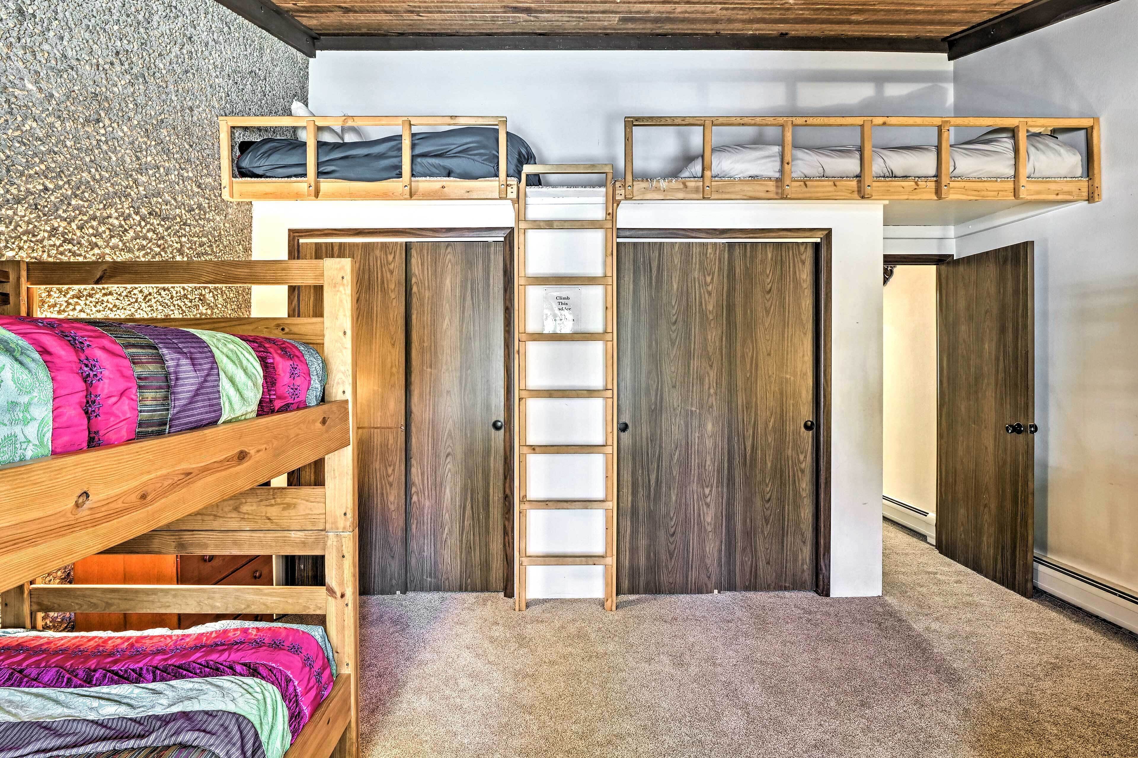 Een slaapkamer met een stapelbed, een houten garderobe en een vloerbedekking.