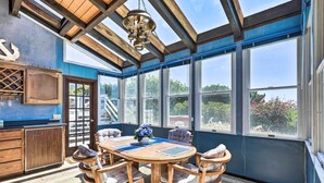 A sunroom with a wooden table and chairs, large windows, and a ceiling fan. - Oceanfront Irish Beach 'sea Haven' Home w/ Hot Tub (Manchester)