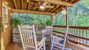 A wooden deck with a ceiling fan, string lights, and a sign reading "The Porch Market." - Cozy Cabin w/ Mountain Views Near Skylift Park! (Gatlinburg)