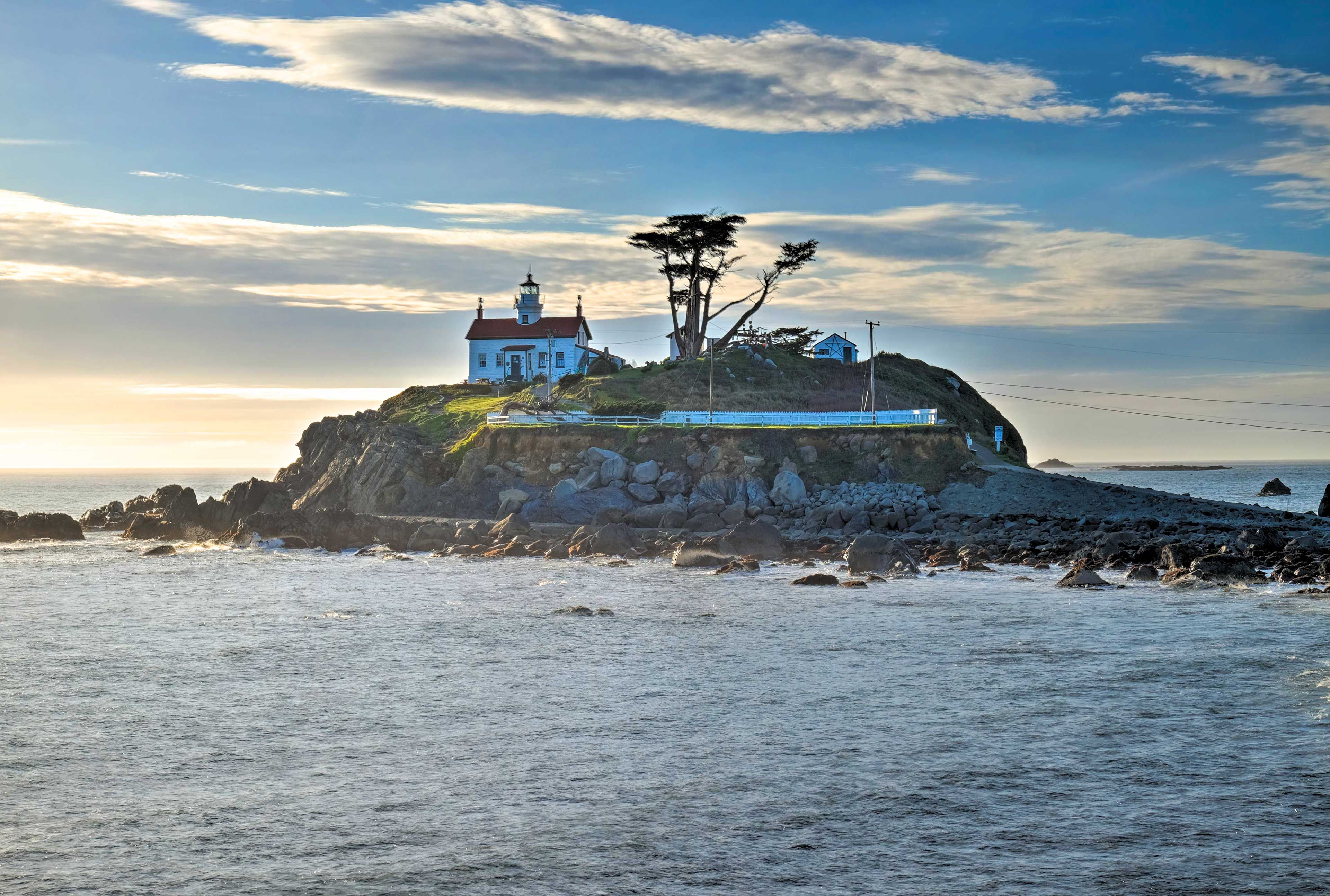 A coastal building with a lighthouse, situated on a rocky outcrop with a view of the sea.