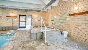 Un área de spa con una bañera de hidromasaje, una piscina pequeña y una sauna.