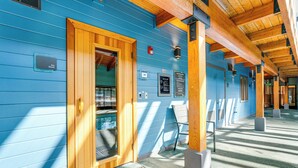 A blue building with a wooden door, a bench, and a sign indicating a sauna. - < 1 Mi to Dtwn: Creekside Frisco Home w/ Fire Pit (Frisco)