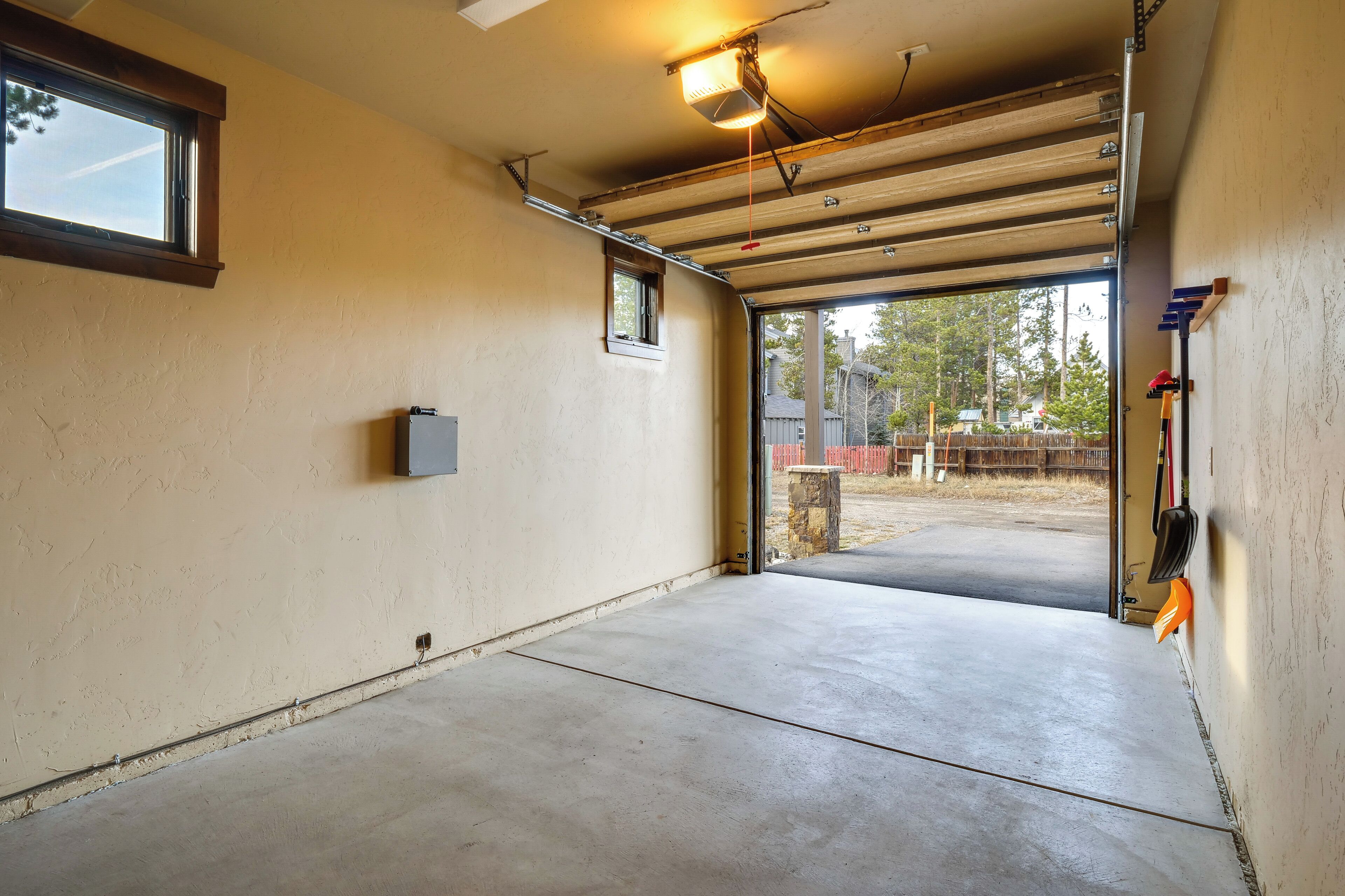 Un garaje con suelo de concreto, una ventana y una puerta de acceso al exterior.