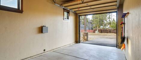 Un garaje con suelo de concreto, una ventana y una puerta de acceso al exterior.