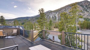 A balcony with a view of a mountainous landscape, outdoor seating, and a wooden table. - Frisco Condo w/ Rooftop Deck: Walk to Main St! (Frisco)