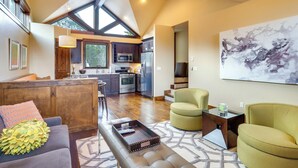 A modern living room with a sofa, a coffee table, and a dining area with chairs. - Frisco Condo w/ Rooftop Deck: Walk to Main St! (Frisco)