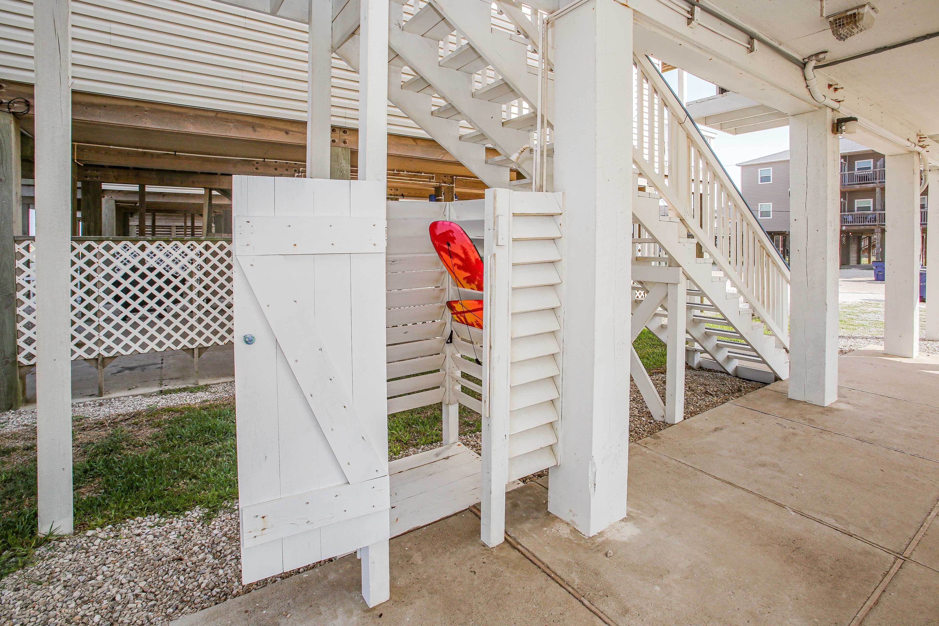 A covered outdoor area with a white wooden staircase and a lattice fence.