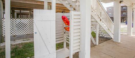 A covered outdoor area with a white wooden staircase and a lattice fence.
