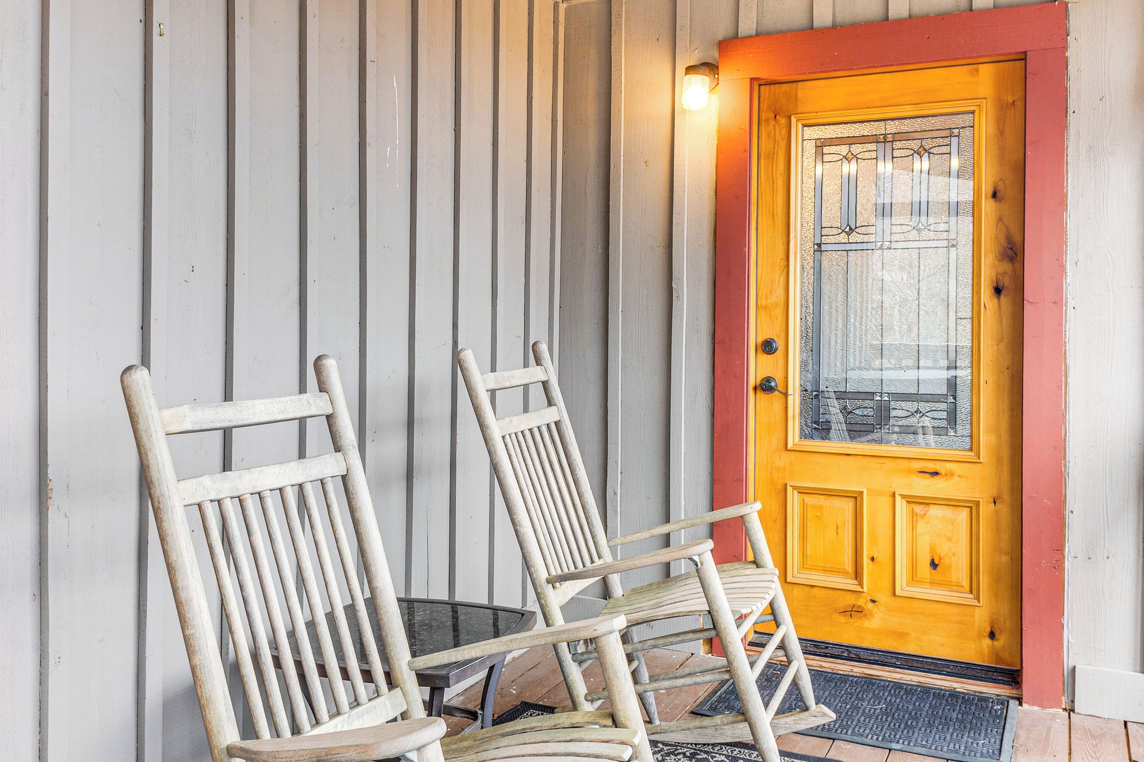 A wooden door with a glass panel and a small light above it.