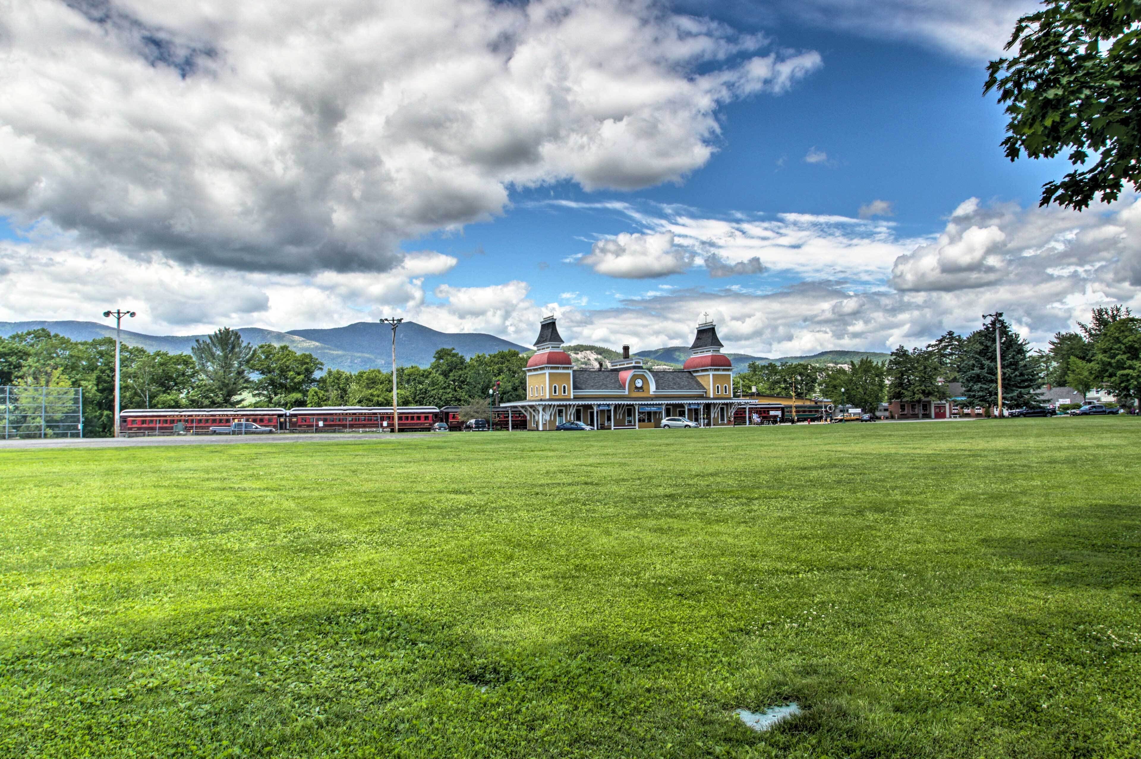 A large grassy field with a building featuring two domed roofs and a red and yellow facade.