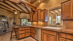 Una cocina con armarios de madera, lavavajillas y un ventanal que proporciona luz natural.