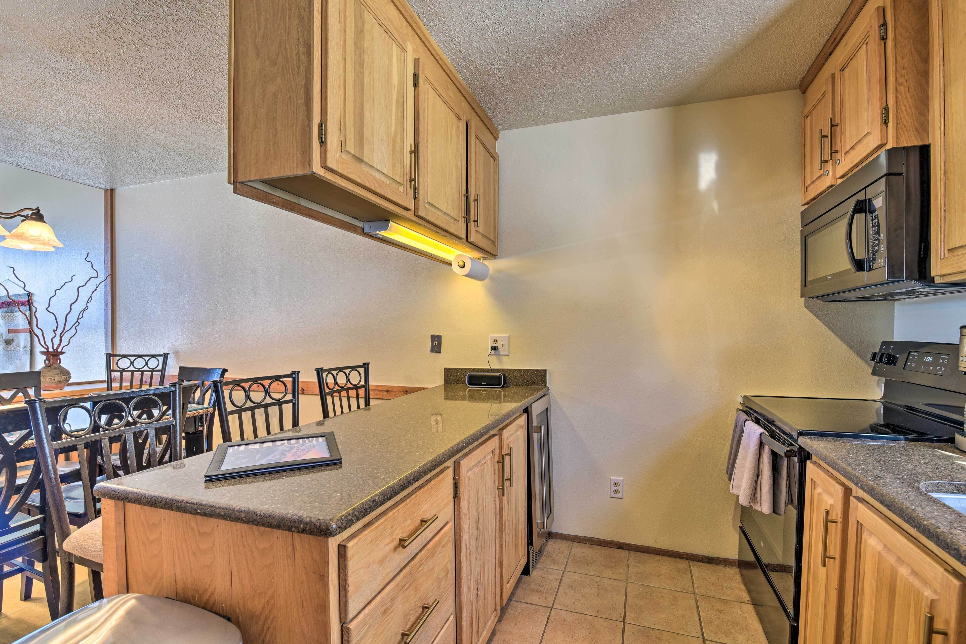 A kitchen with wooden cabinets, a granite countertop, a built-in microwave, and a gas stove.