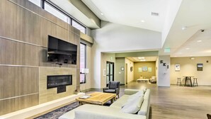 Un hall d’entrée moderne avec un canapé, une table basse et une cheminée.