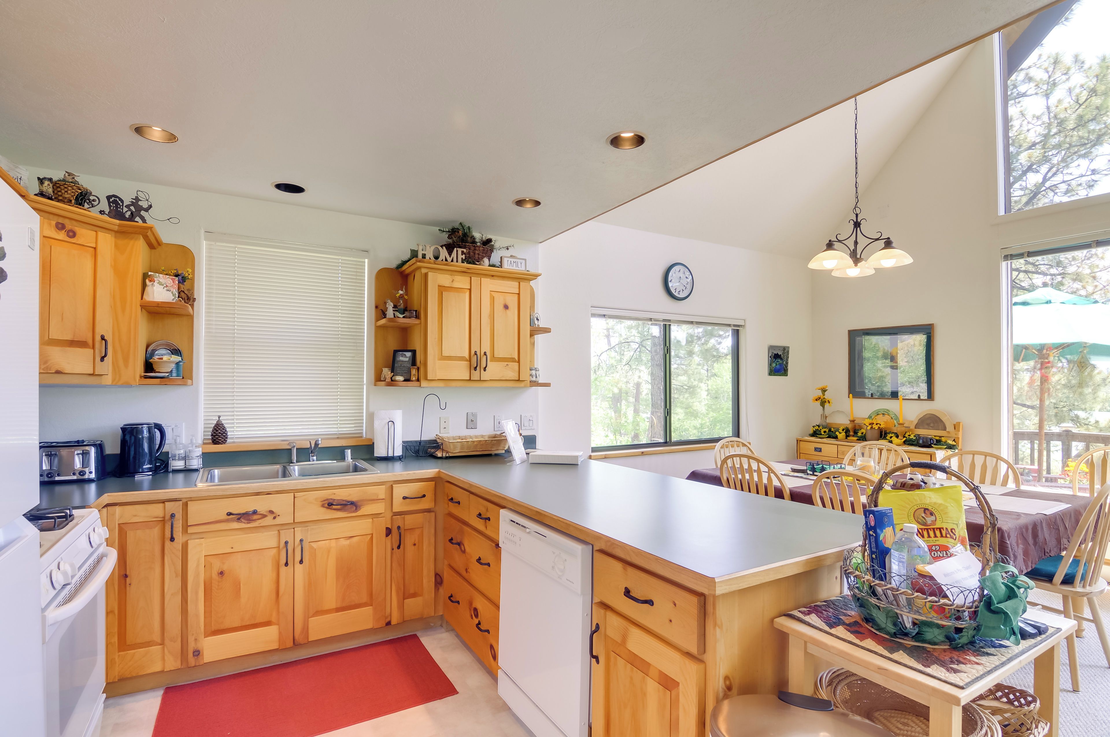 A modern kitchen with wooden cabinets, a dishwasher, and a large island.