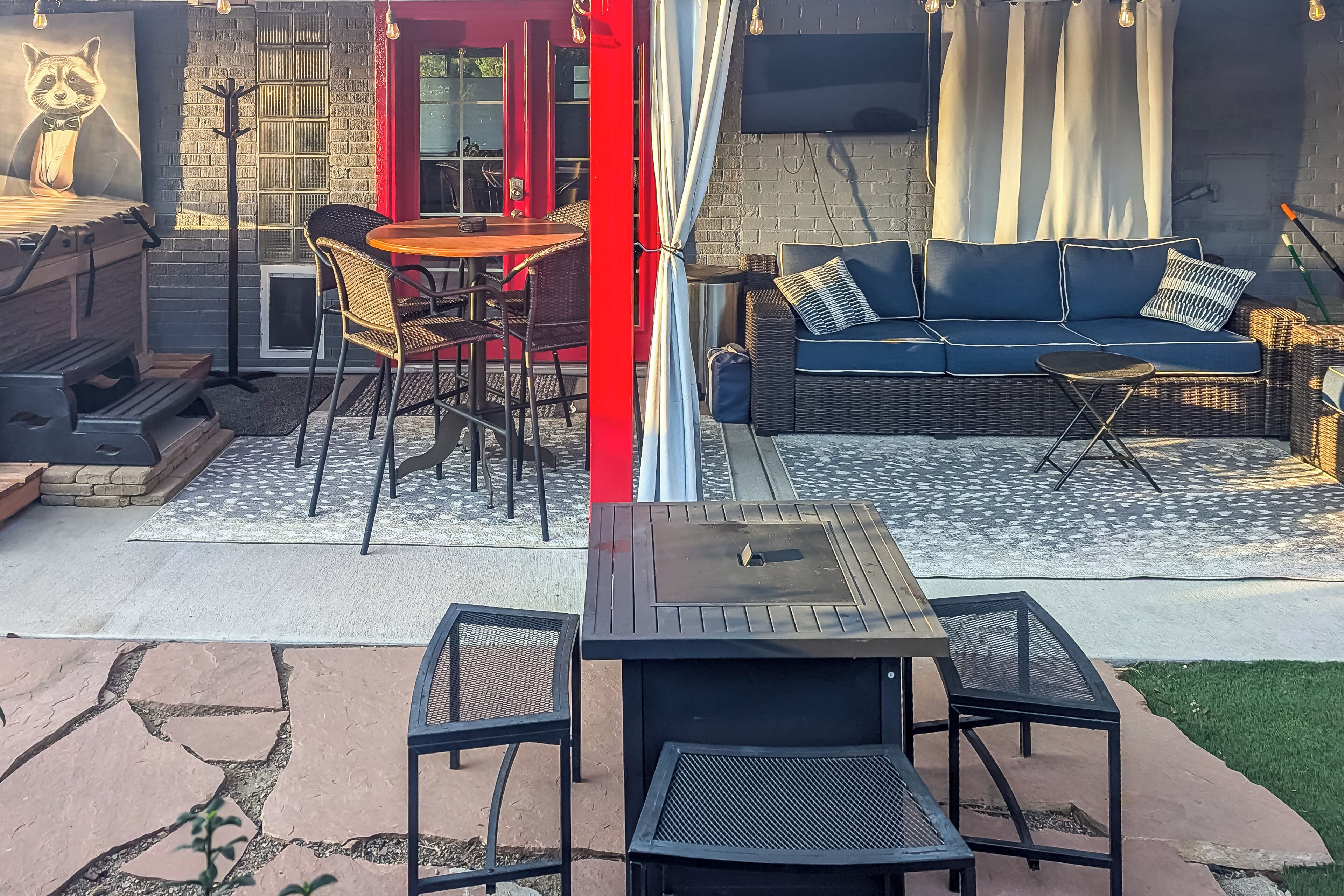 An outdoor patio area with a dining table, chairs, a sofa, and a grill.
