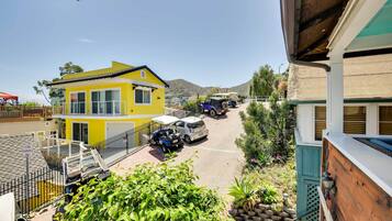 A yellow building with a white roof, a parked car, and a blue vehicle.