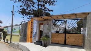 Um edifício com fachada de pedra, um portão de madeira e uma área de entrada coberta.