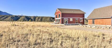 A red barn with a porch and a stone foundation.