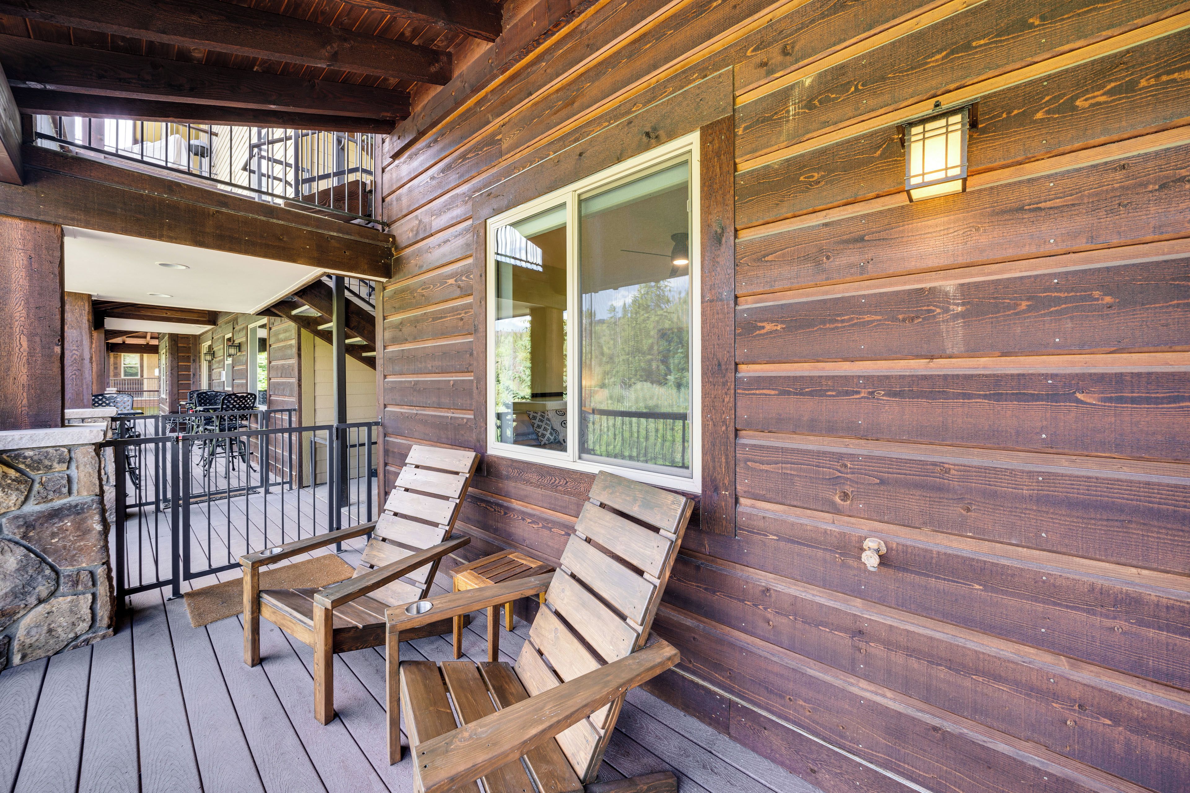 A wooden deck with outdoor seating and a view of the interior.