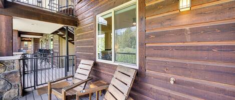 A wooden deck with outdoor seating and a view of the interior.