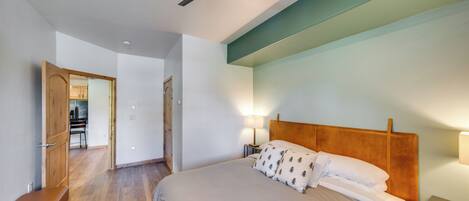 Ein Schlafzimmer mit Bett, Nachttischlampen, Deckenventilator und einer Holzbank.