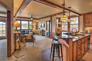 Una cocina amplia con armarios de madera, una isla grande e iluminación colgante.