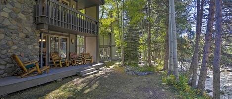 A stone building with a balcony and outdoor seating area.